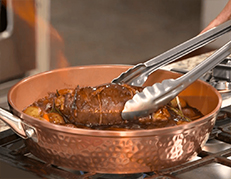 Grabbing pot roast with metal tongs